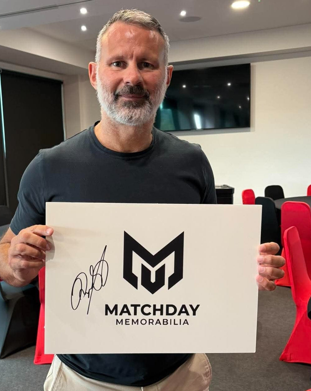 Ryan Giggs holding a signed Matchday Memorabilia board